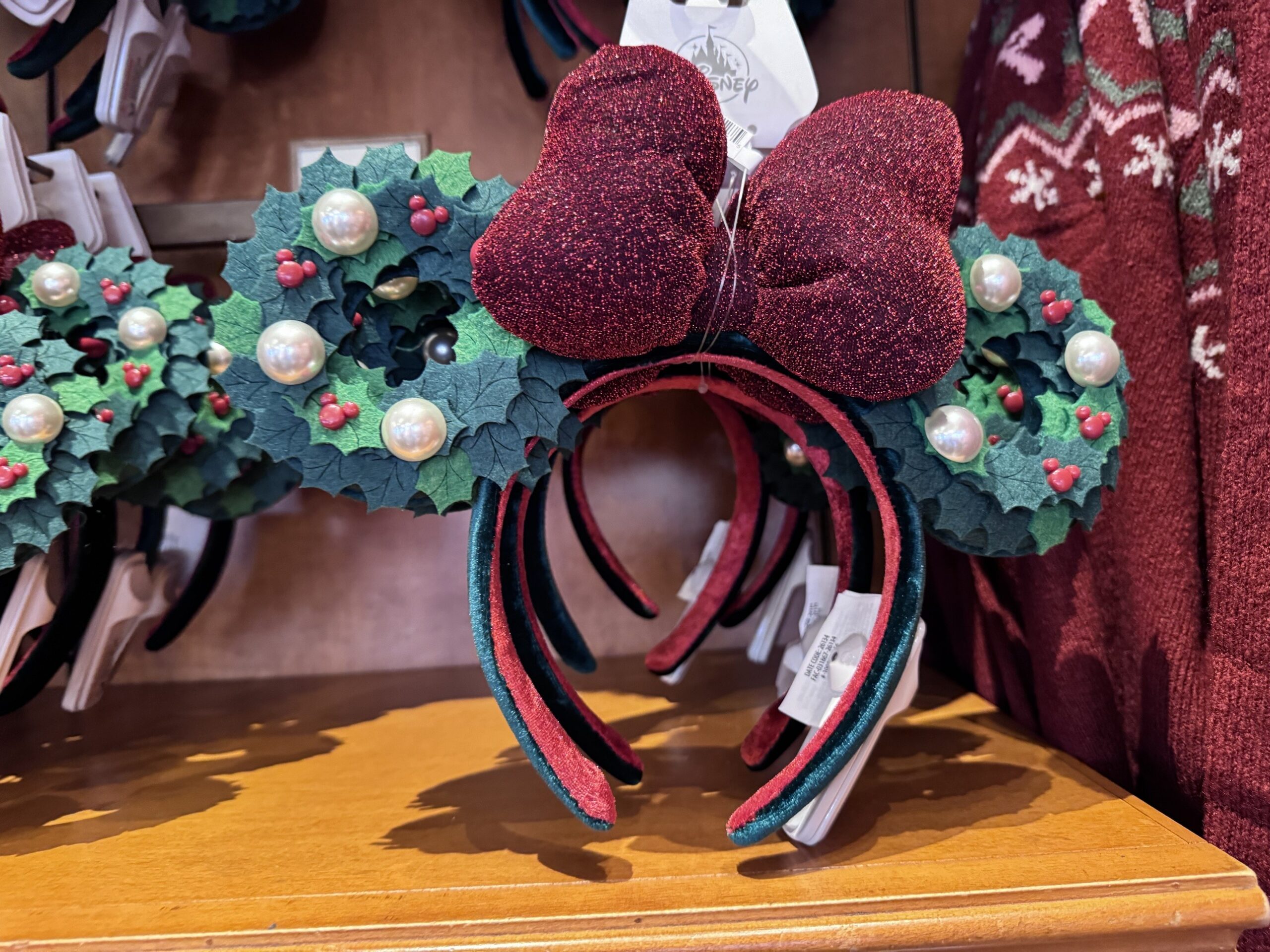 Holly wreath Minnie ears with pearls, Mickey-shaped berries and a glittery burgundy bow