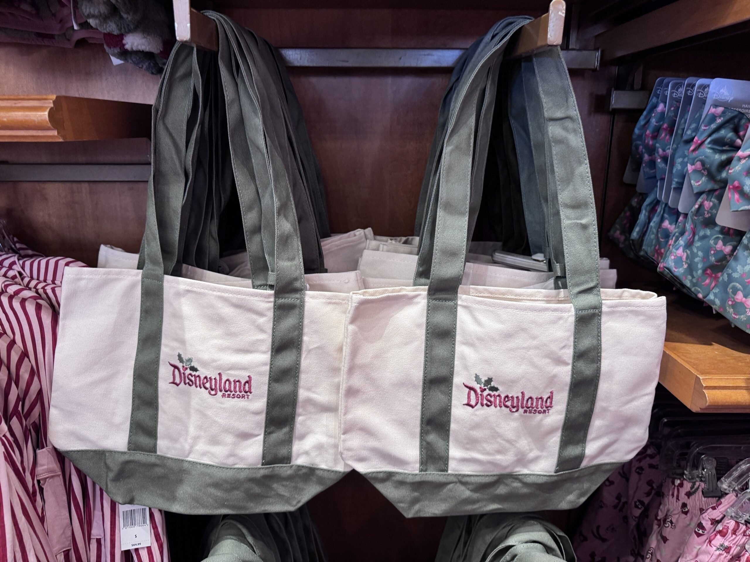 Cream and sage canvas totes embroidered with a burgundy Disneyland Resort logo and holly