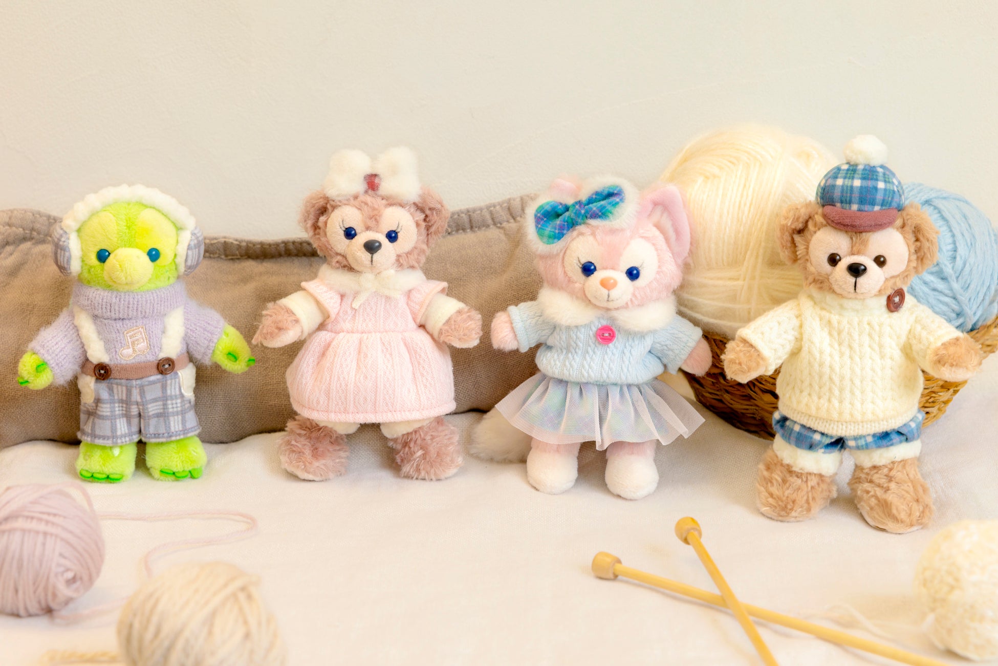 Duffy, ShellieMay, LinaBell and 'Olu Mel plush in Making Winter Warm knit outfits beside balls of yarn and knitting needles