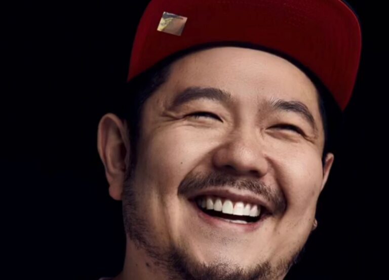 Eric Bauza smiling in a red cap