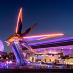 The Nova Corps Starblaster ship outside Guardians of the Galaxy: Cosmic Rewind at night, with Spaceship Earth and a monorail behind it at EPCOT