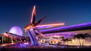 The Nova Corps Starblaster ship outside Guardians of the Galaxy: Cosmic Rewind at night, with Spaceship Earth and a monorail behind it at EPCOT