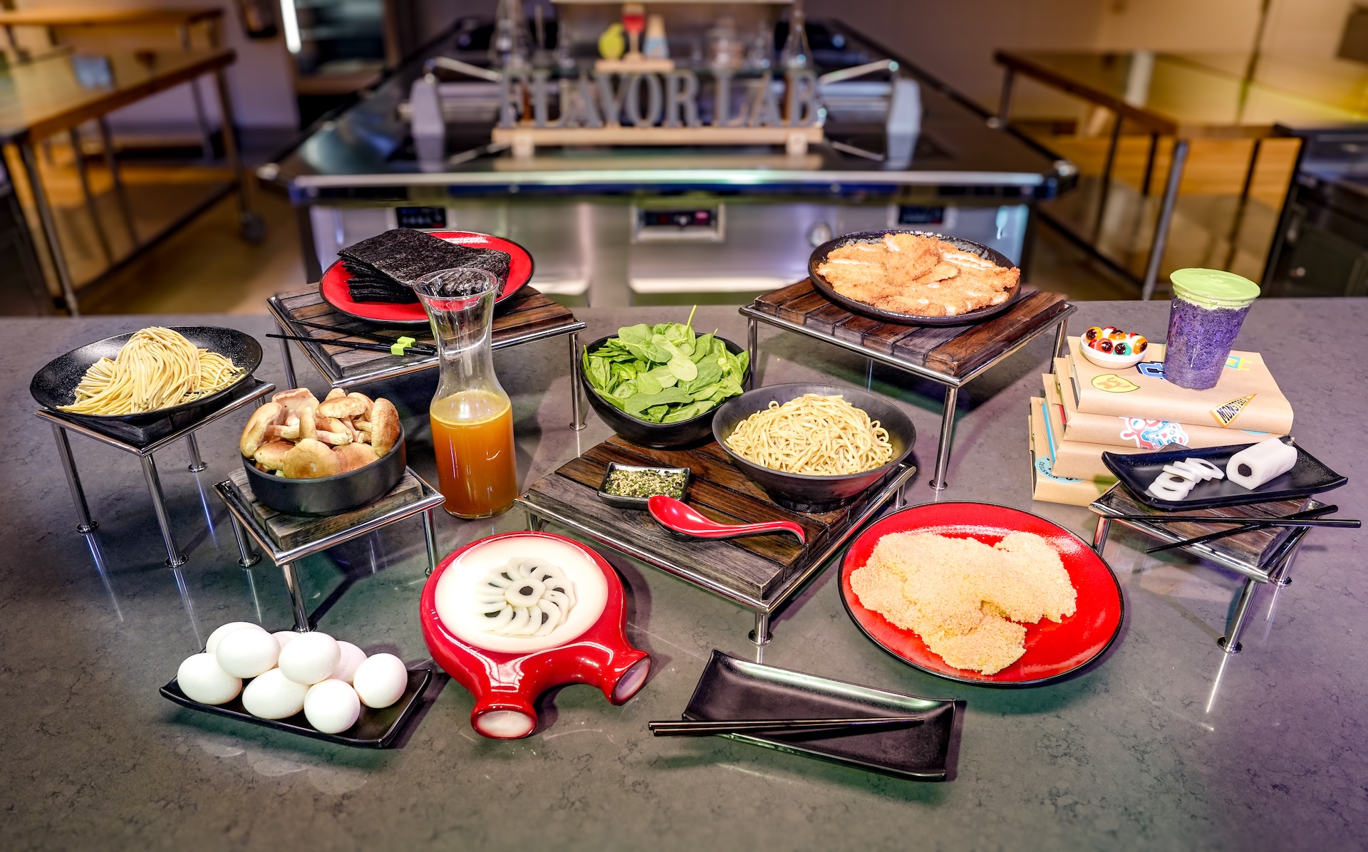 Ramen ingredients laid out on a test kitchen counter for Harryhausen's in Monstropolis, including noodles, broth in a carafe, eggs, spinach, mushrooms, nori and fishcake sliced to look like eyeballs. (Disney)