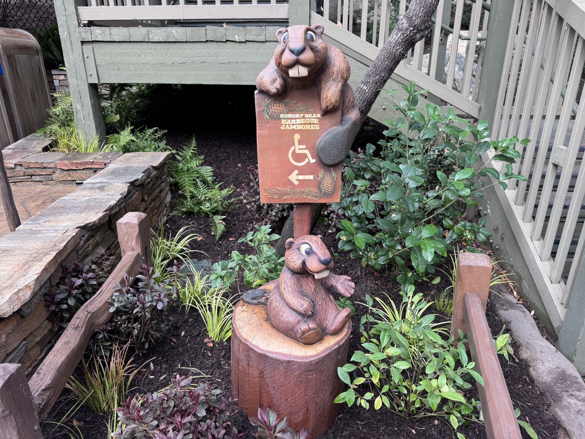 Carved beavers holding the accessibility sign at Hungry Bear Barbecue Jamboree