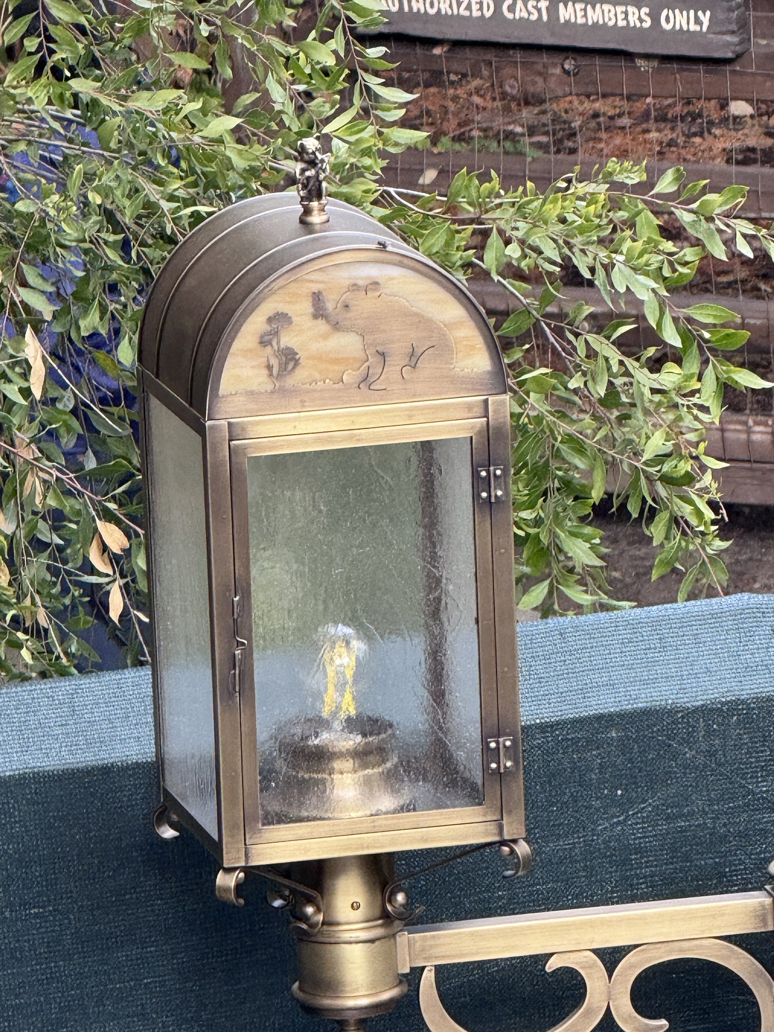 A Hungry Bear Barbecue Jamboree lantern with an etched bear sniffing flowers