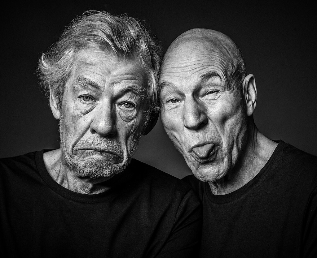Ian McKellen and Patrick Stewart pose together making silly faces in a black-and-white portrait