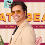 John Stamos in front of EPCOT's Eat to the Beat concert series artwork