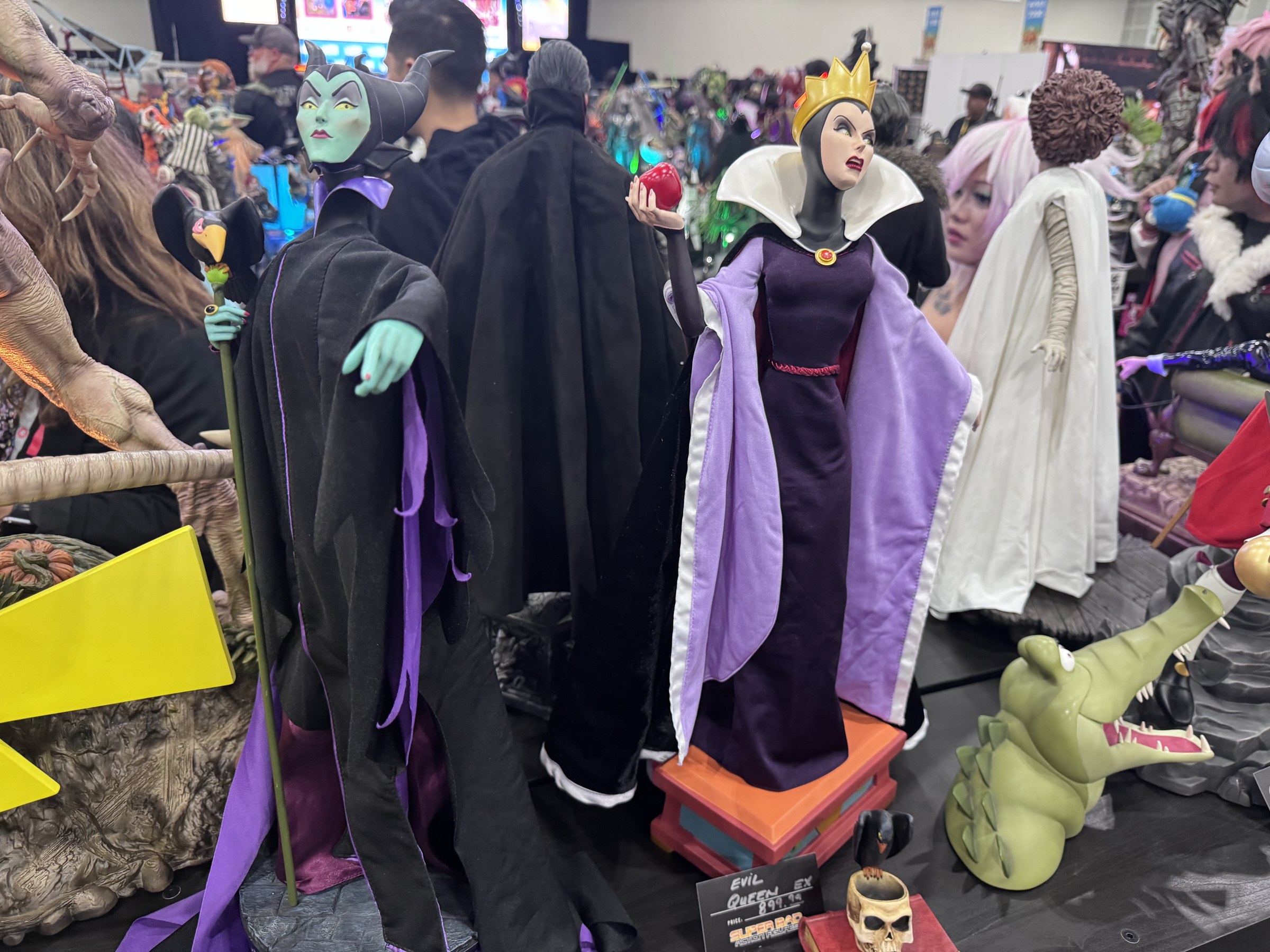 Maleficent and Evil Queen figures with cloth costumes, the Evil Queen tagged $899.99, on the Super Bad Action Figures table
