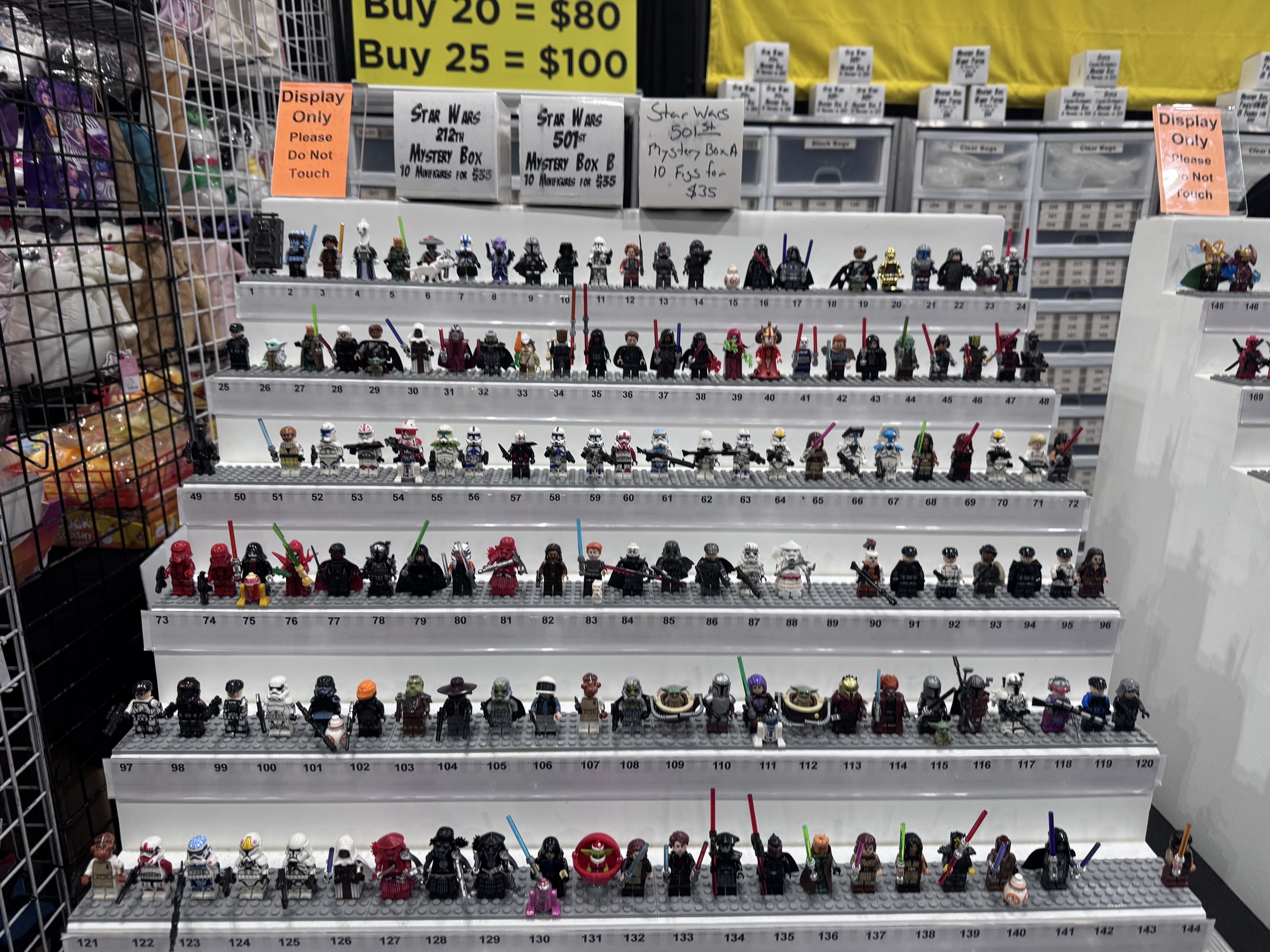 Tiered shelves packed with Star Wars minifigures under mystery box and bulk pricing signs