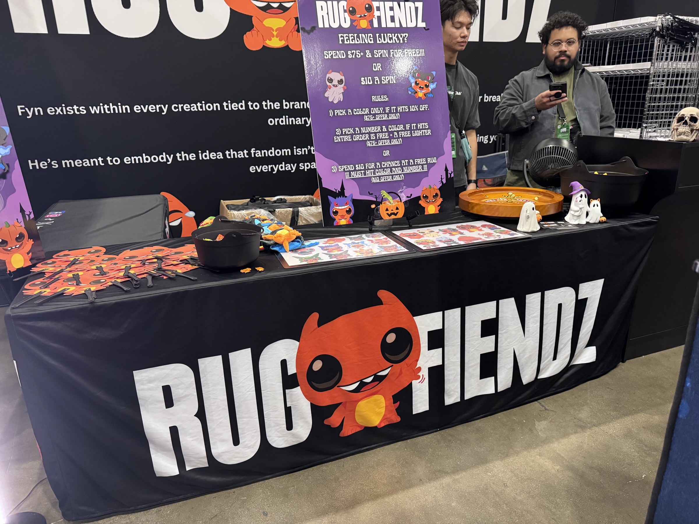 The Rug Fiendz table with a Feeling Lucky spin sign and Halloween decorations