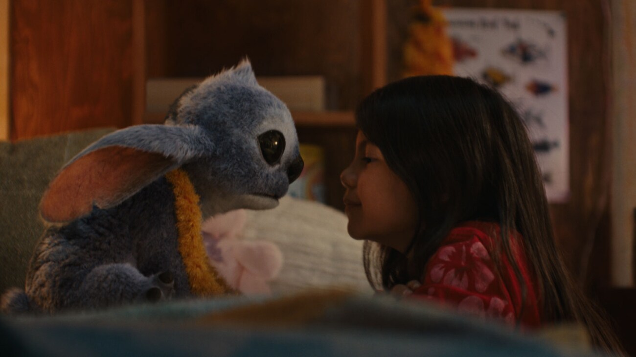 Stitch with a yellow lei faces Lilo in her bedroom in a still from Disney's 2025 live-action Lilo & Stitch