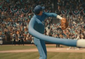 Pedro Pascal's Mister Fantastic in a blue Fantastic Four baseball uniform stretching his arm to throw the first pitch at Ebbets Field