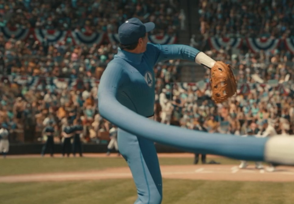 Pedro Pascal's Mister Fantastic in a blue Fantastic Four baseball uniform stretching his arm to throw the first pitch at Ebbets Field