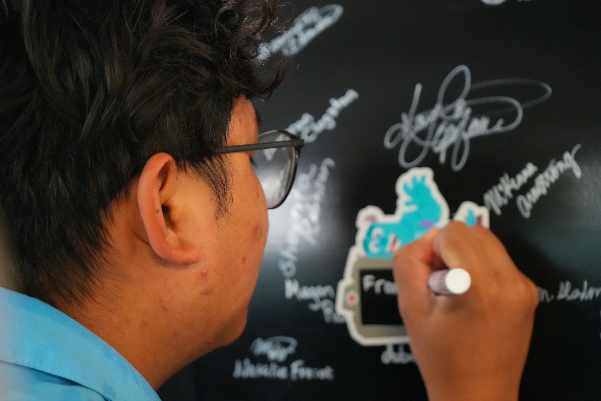 A Cast Member signs a beam for the Monsters, Inc. roller coaster at Disney's Hollywood Studios