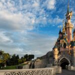 Sleeping Beauty Castle at Disneyland Paris on a sunny day with its bridge balustrade in the foreground
