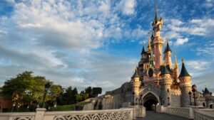 Sleeping Beauty Castle at Disneyland Paris on a sunny day with its bridge balustrade in the foreground