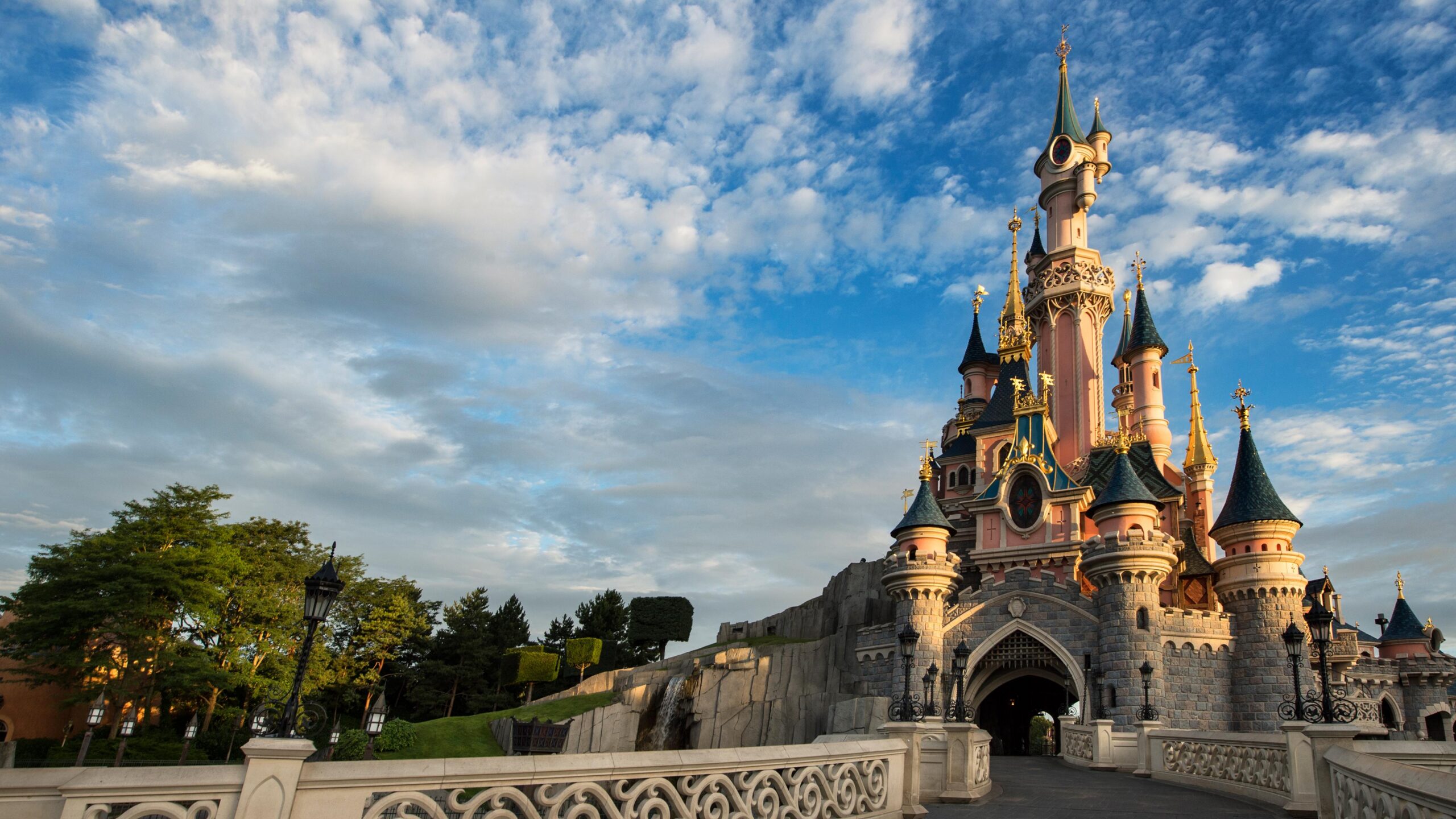 Sleeping Beauty Castle at Disneyland Paris on a sunny day with its bridge balustrade in the foreground