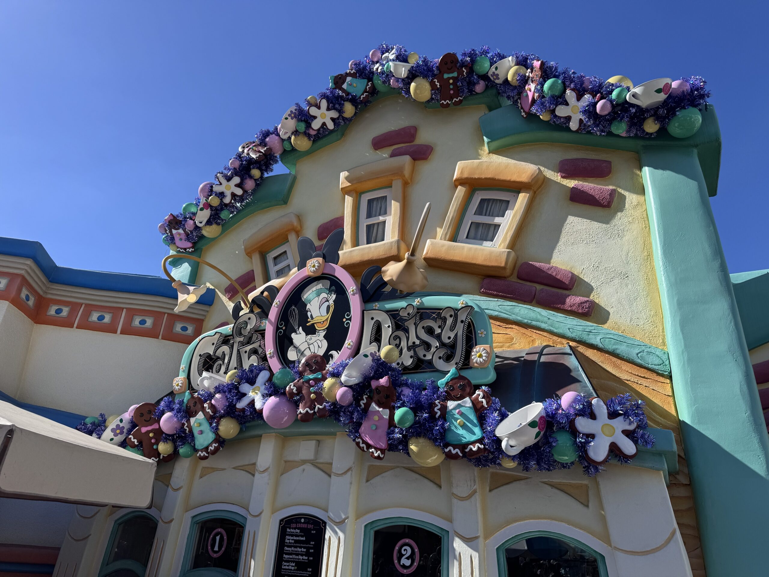 Purple garland with gingerbread cookies and teacups on Cafe Daisy in Mickey's Toontown at Disneyland
