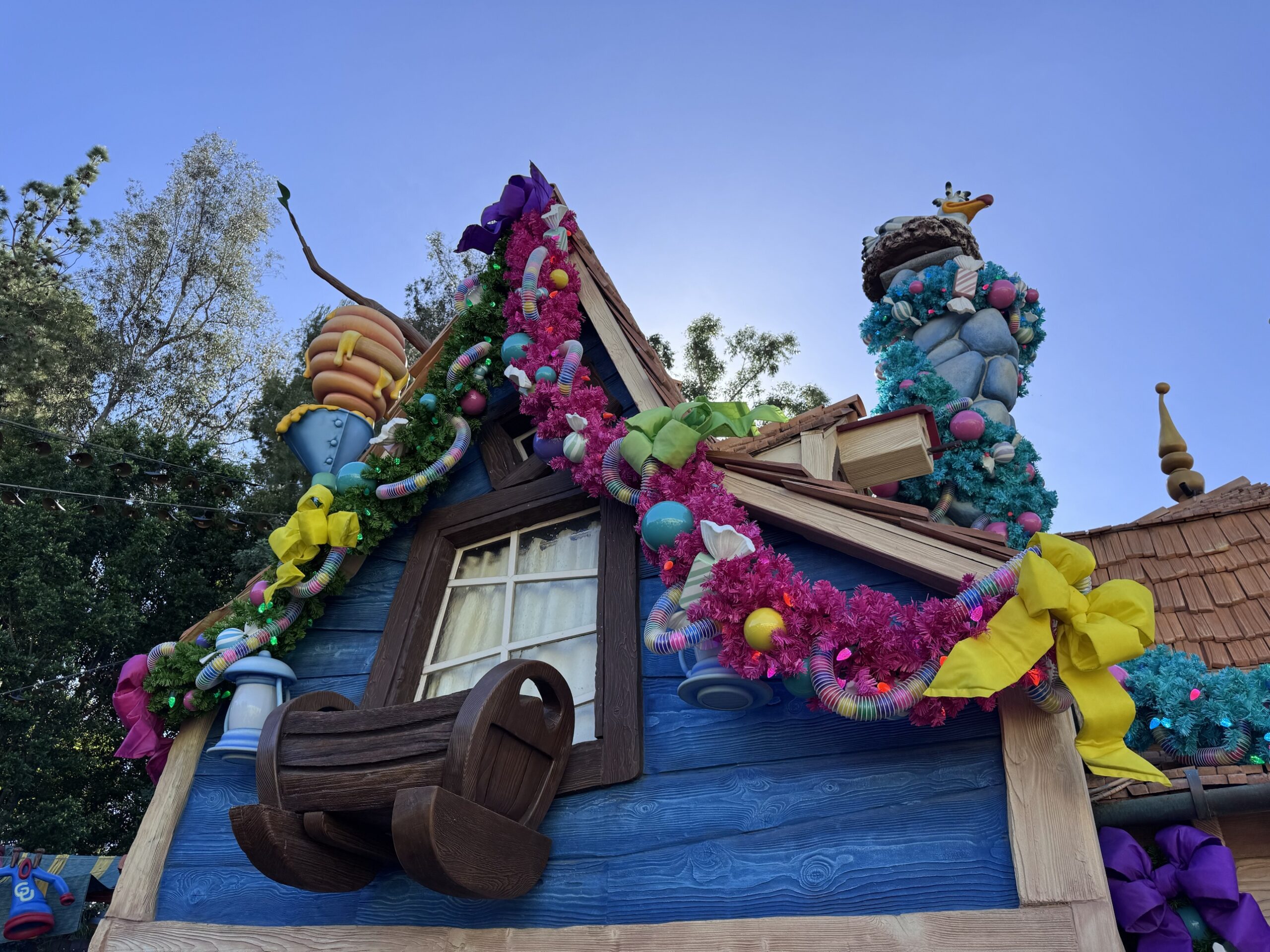 Pink and green garland with spring toys and yellow bows on Goofy's house in Toontown at Disneyland