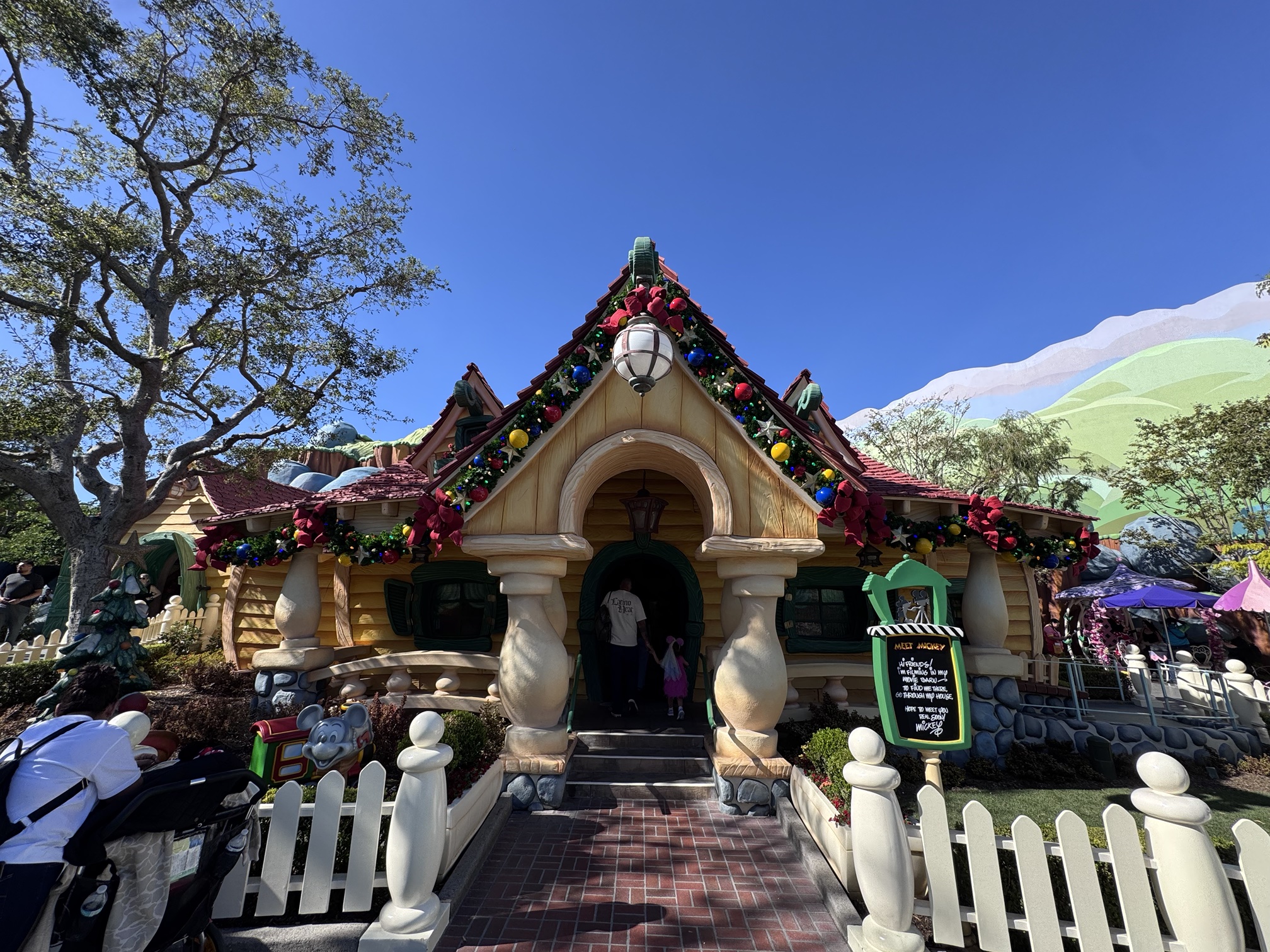 Christmas garland with red bows on the front of Mickey's House in Toontown at Disneyland
