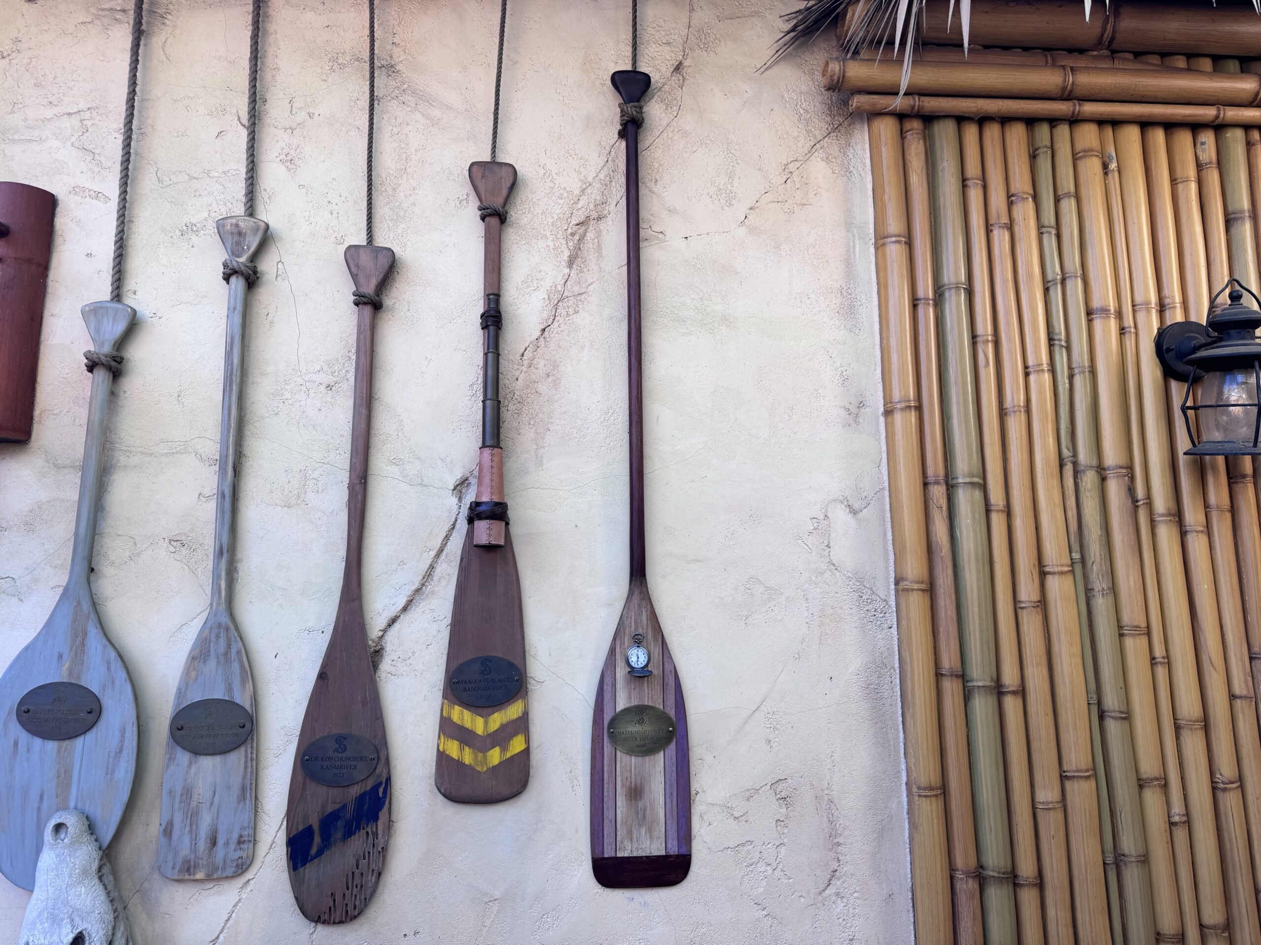 Wall of S.E.A. member oars under a thatched roof at The Tropical Hideaway, with Hazel Hightower's oar at the far right